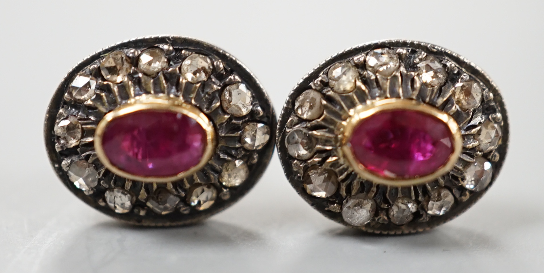 A pair of yellow metal, ruby and rose cut diamond set oval cluster earrings, 10mm, gross 3.2 grams.